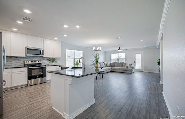 14755 Grey Egret Run, San Antonio, TX 78253 - kitchen featuring stainless steel appliances, open floor plan, baseboards, light wood-style floors, and crown molding