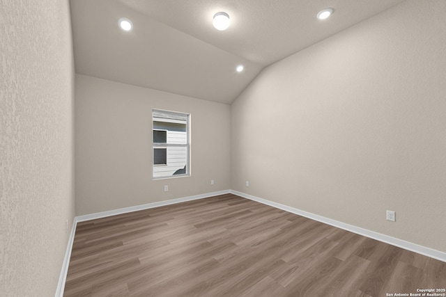 22111 Jordans Pl, San Antonio, TX 78264 - spare room with wood finished floors, vaulted ceiling, recessed lighting, and baseboards