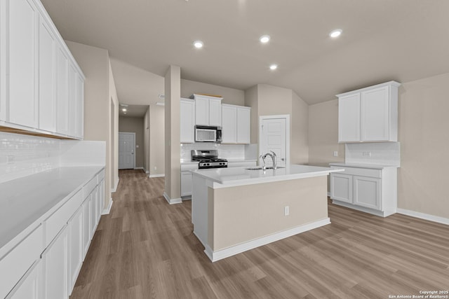 22111 Jordans Pl, San Antonio, TX 78264 - kitchen featuring stainless steel appliances, a sink, decorative backsplash, light wood-type flooring, and baseboards