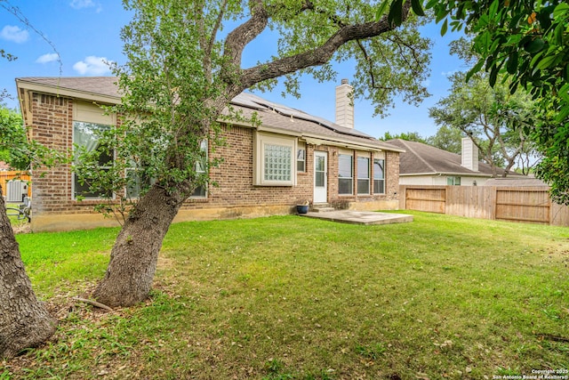22207 Impala Peak, San Antonio, TX 78259 - back of house with brick siding, a patio area, solar panels, and a chimney
