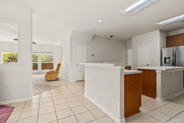 22207 Impala Peak, San Antonio, TX 78259 - kitchen with a kitchen island, stainless steel fridge with ice dispenser, light tile patterned floors, light countertops, and baseboards
