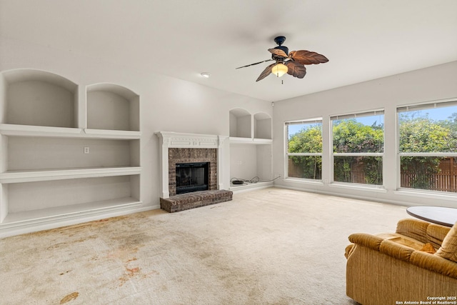 22207 Impala Peak, San Antonio, TX 78259 - carpeted living area featuring built in shelves, ceiling fan, and a brick fireplace
