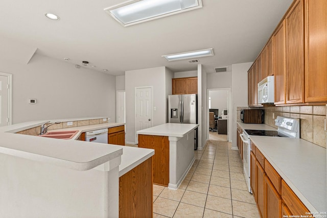 22207 Impala Peak, San Antonio, TX 78259 - kitchen with white appliances, a sink, a large island, light tile patterned floors, and tasteful backsplash