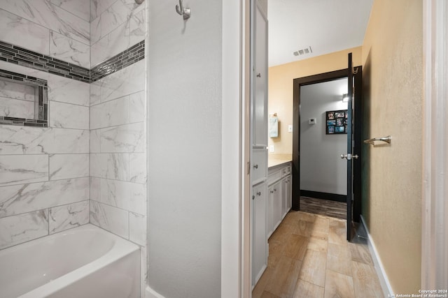1215 Amanda, Canyon Lake, TX 78133 - bathroom featuring vanity, baseboards, shower / washtub combination, and wood finished floors
