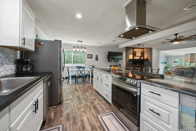 1215 Amanda, Canyon Lake, TX 78133 - kitchen with appliances with stainless steel finishes, island exhaust hood, dark countertops, white cabinets, and dark wood-type flooring