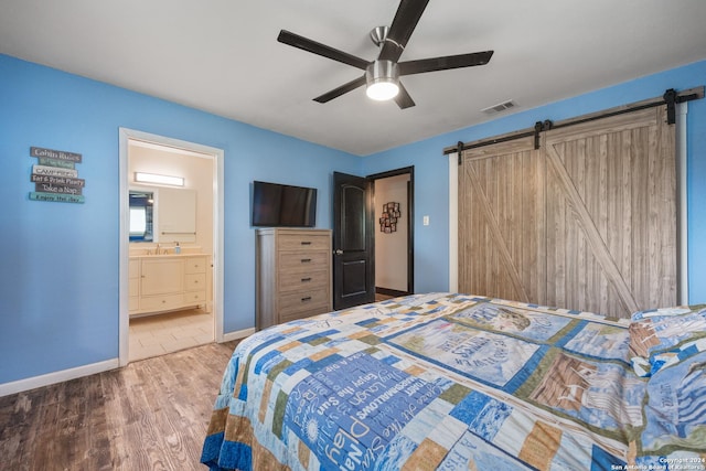 1215 Amanda, Canyon Lake, TX 78133 - bedroom with wood finished floors, a barn door, baseboards, and ceiling fan
