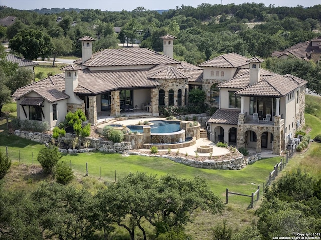 35 Winged Foot, Boerne, TX 78006 - back of property with stone siding, a chimney, stucco siding, and a pool with connected hot tub