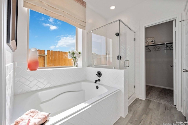 11212 Schmidt Ln, Converse, TX 78109 - bathroom featuring a garden tub, a walk in closet, a stall shower, wood finished floors, and recessed lighting