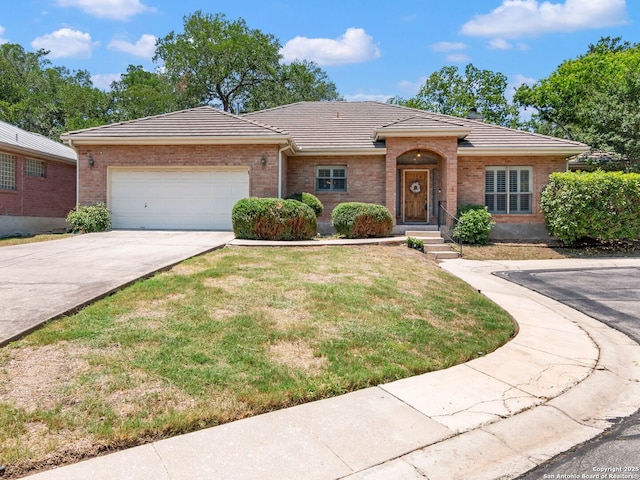 6 Oakwell Farms, San Antonio, TX 78218 - view of front facade with an attached garage, a tile roof, concrete driveway, a front lawn, and brick siding