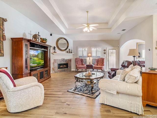 6 Oakwell Farms, San Antonio, TX 78218 - living area featuring a raised ceiling, a ceiling fan, a high end fireplace, light wood-type flooring, and arched walkways