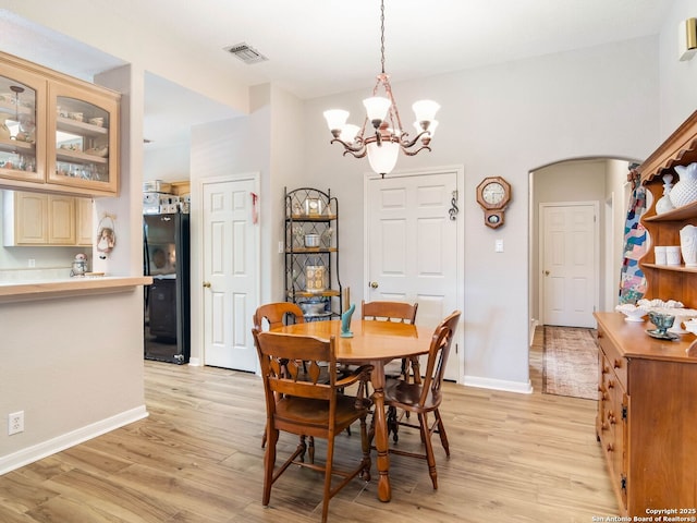 6 Oakwell Farms, San Antonio, TX 78218 - dining area featuring arched walkways, a chandelier, light wood finished floors, and baseboards