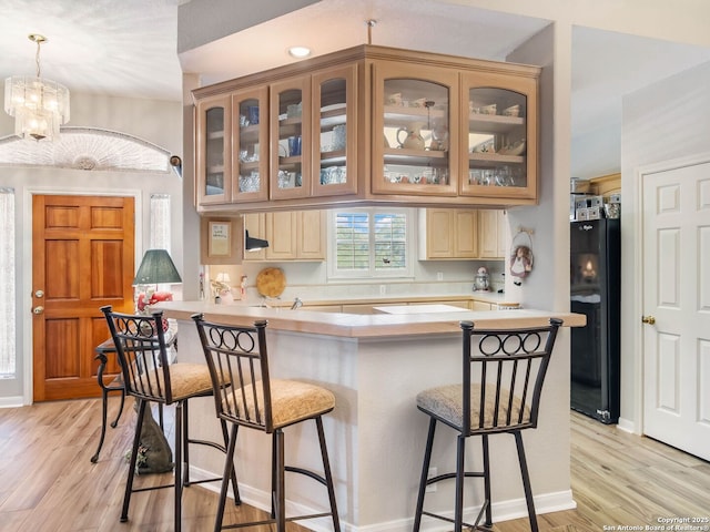 6 Oakwell Farms, San Antonio, TX 78218 - kitchen with freestanding refrigerator, a kitchen breakfast bar, light wood-style flooring, and light countertops