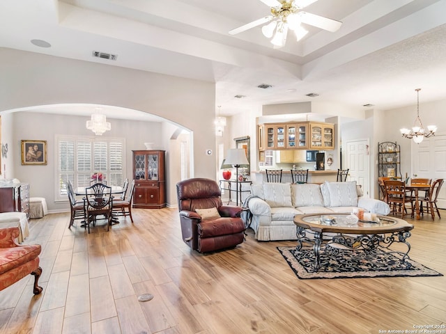 6 Oakwell Farms, San Antonio, TX 78218 - living room featuring a chandelier, arched walkways, a tray ceiling, and light wood-style floors
