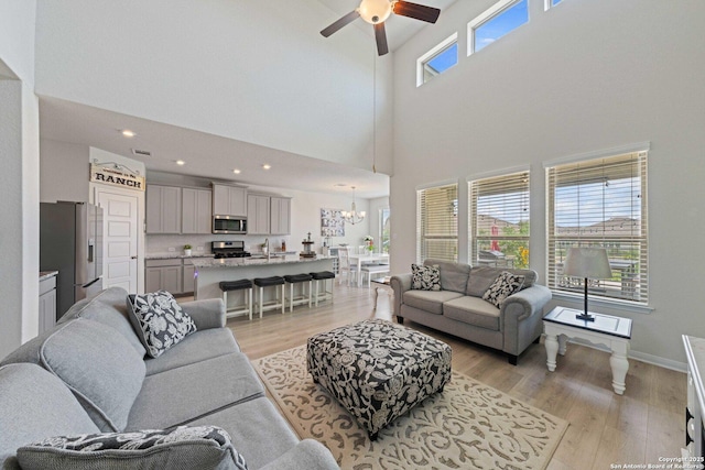 112 La Cima, Boerne, TX 78006 - living room featuring a towering ceiling, light wood-style floors, a ceiling fan, a chandelier, and recessed lighting