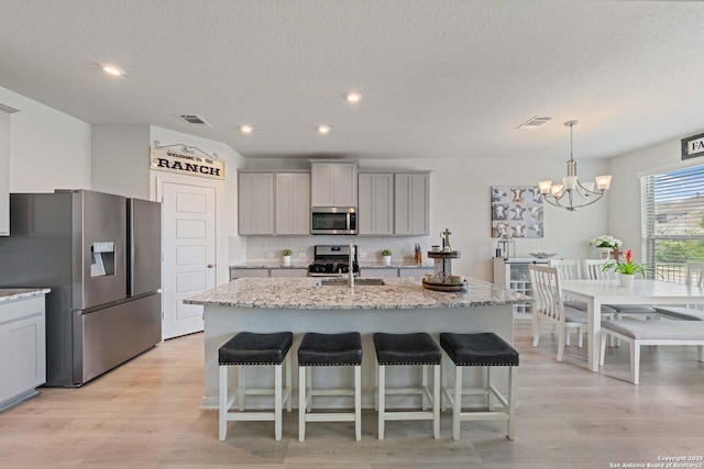 112 La Cima, Boerne, TX 78006 - kitchen featuring appliances with stainless steel finishes, gray cabinetry, a chandelier, a sink, and a textured ceiling