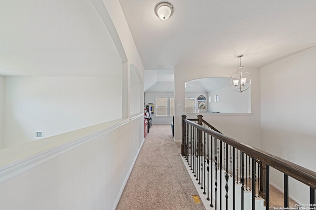 112 La Cima, Boerne, TX 78006 - hall with light carpet, baseboards, arched walkways, a chandelier, and an upstairs landing