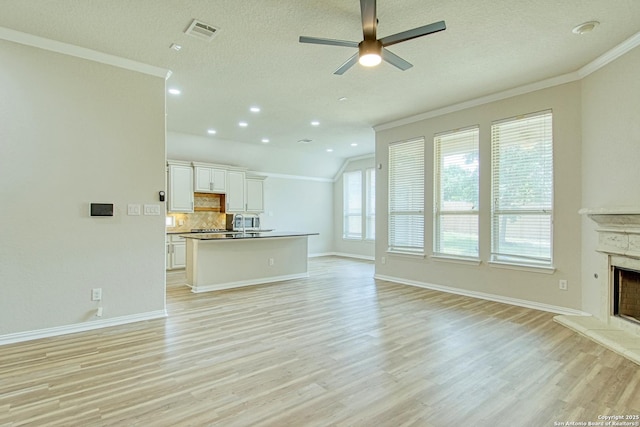 12902 Gypsophila, San Antonio, TX 78253 - unfurnished living room with ornamental molding, light wood finished floors, a high end fireplace, baseboards, and a ceiling fan