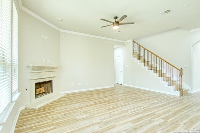 12902 Gypsophila, San Antonio, TX 78253 - unfurnished living room with stairway, light wood-style floors, ceiling fan, a fireplace with raised hearth, and crown molding