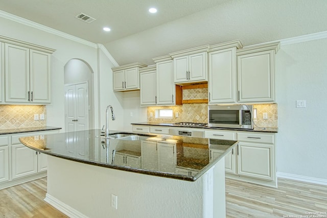12902 Gypsophila, San Antonio, TX 78253 - kitchen featuring appliances with stainless steel finishes, light wood finished floors, a sink, crown molding, and a kitchen island with sink