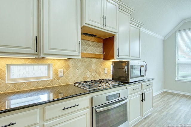 12902 Gypsophila, San Antonio, TX 78253 - kitchen with appliances with stainless steel finishes, vaulted ceiling, dark stone counters, baseboards, and light wood-style floors