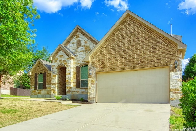 12902 Gypsophila, San Antonio, TX 78253 - french country style house featuring stone siding, a garage, concrete driveway, and brick siding