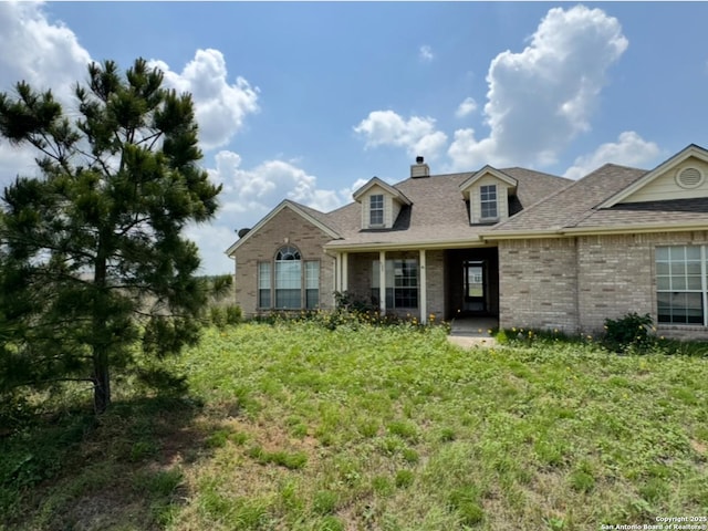 135 Muirfield Ln, Vernia, TX 78121 - view of front of home featuring brick siding, a chimney, and a shingled roof