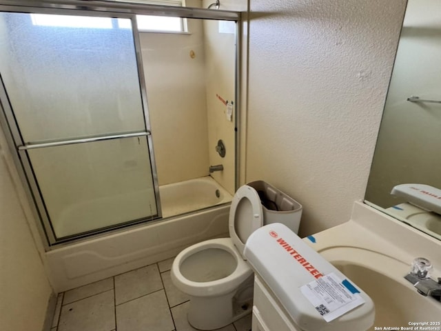 135 Muirfield Ln, Vernia, TX 78121 - bathroom featuring toilet, bath / shower combo with glass door, tile patterned flooring, and a textured wall
