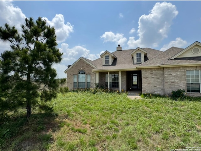 135 Muirfield Ln, Vernia, TX 78121 - view of front of home featuring brick siding, a chimney, and roof with shingles