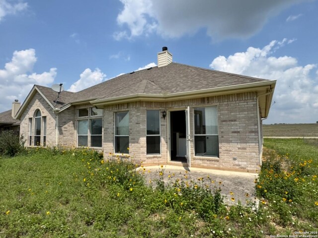 135 Muirfield Ln, Vernia, TX 78121 - back of property featuring brick siding, a chimney, and roof with shingles