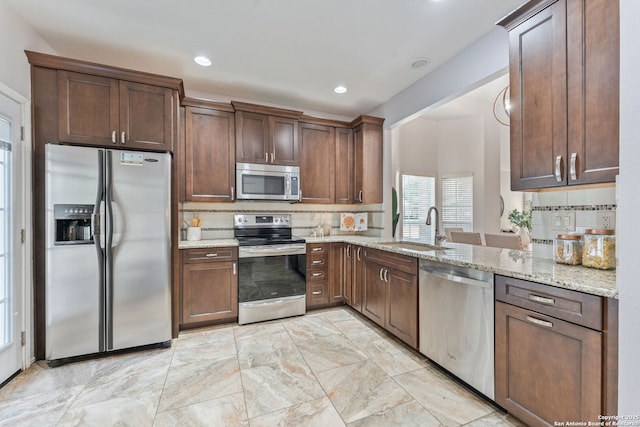 17915 Crystal Knl, San Antonio, TX 78258 - kitchen with stainless steel appliances, a sink, tasteful backsplash, light stone counters, and recessed lighting