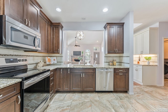 17915 Crystal Knl, San Antonio, TX 78258 - kitchen featuring appliances with stainless steel finishes, a sink, ceiling fan, decorative backsplash, and dark brown cabinets