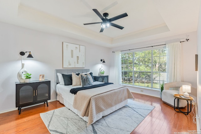 17915 Crystal Knl, San Antonio, TX 78258 - bedroom featuring a tray ceiling, crown molding, light wood-style floors, and ceiling fan