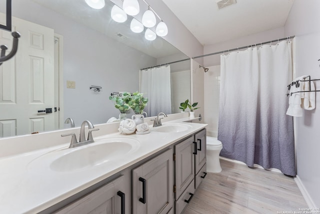 17915 Crystal Knl, San Antonio, TX 78258 - full bath featuring double vanity, toilet, wood finished floors, and curtained shower