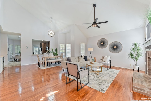 17915 Crystal Knl, San Antonio, TX 78258 - living room with high vaulted ceiling, healthy amount of natural light, a fireplace, light wood finished floors, and a ceiling fan
