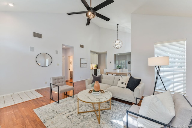 17915 Crystal Knl, San Antonio, TX 78258 - living room with a ceiling fan, a chandelier, wood finished floors, baseboards, and high vaulted ceiling