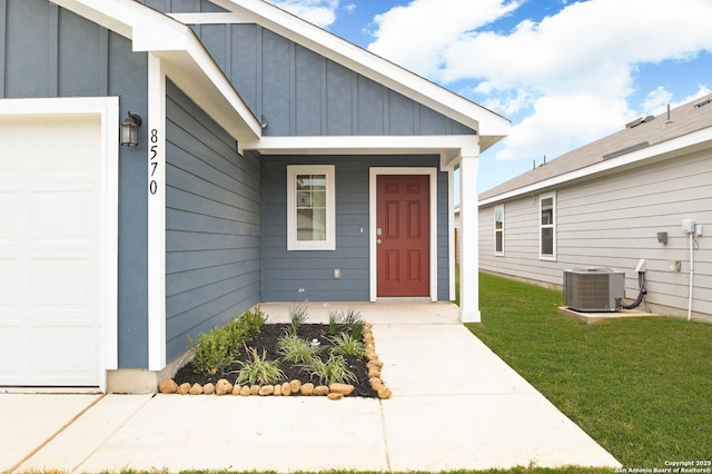 8570 Redhawk Lp, San Antonio, TX 78222 - property entrance with board and batten siding, a garage, central AC, a porch, and a yard