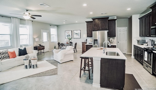158 Landing Ln, New Braunfels, TX 78130 - kitchen featuring stainless steel appliances, a sink, open floor plan, a kitchen breakfast bar, and light countertops