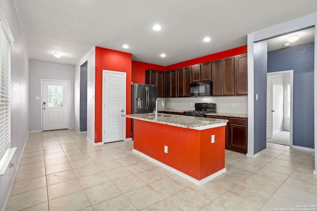 148 Whitetail, San Antonio, TX 78253 - kitchen with gas stove, stainless steel refrigerator with ice dispenser, black microwave, a sink, and a kitchen island with sink
