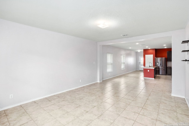 148 Whitetail, San Antonio, TX 78253 - unfurnished living room featuring a sink, light tile patterned flooring, recessed lighting, and baseboards