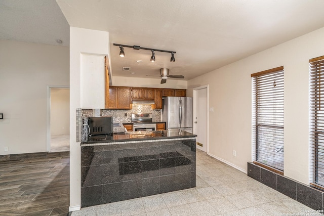 3202 Morning Crk, San Antonio, TX 78247 - kitchen with stainless steel appliances, brown cabinetry, backsplash, dark countertops, and ceiling fan