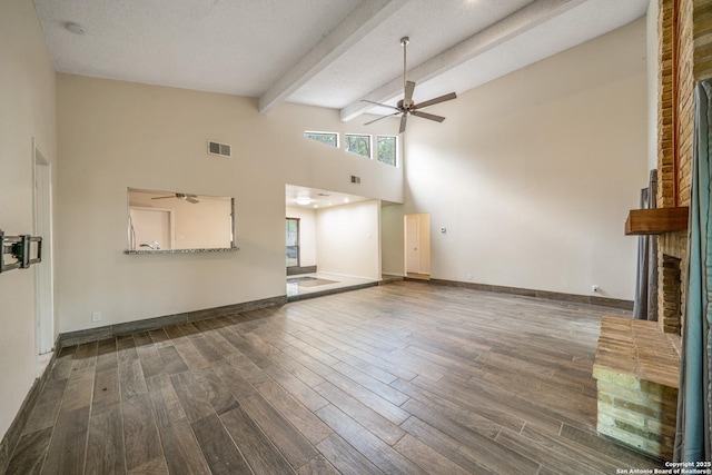 3202 Morning Crk, San Antonio, TX 78247 - unfurnished living room with a ceiling fan, high vaulted ceiling, wood finished floors, a fireplace, and beamed ceiling