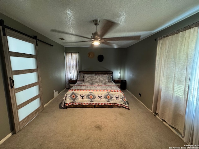 1817 Dusk Dr, Killeen, TX 76543 - carpeted bedroom featuring a barn door, a textured ceiling, a ceiling fan, and baseboards