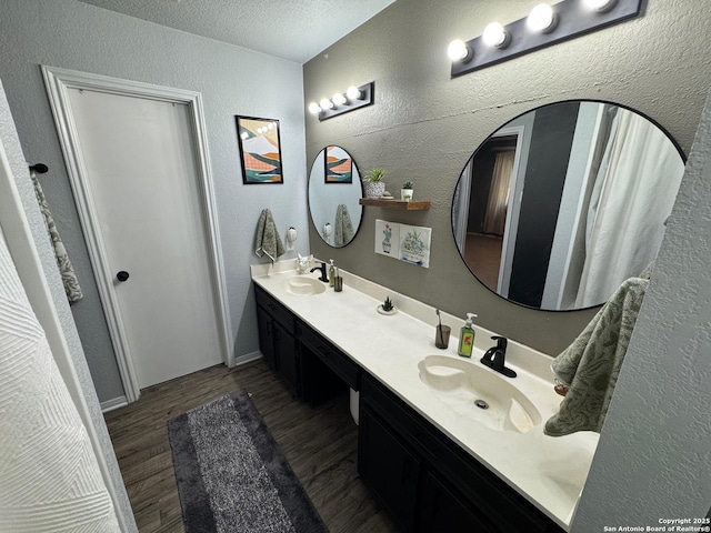 1817 Dusk Dr, Killeen, TX 76543 - bathroom with a textured wall, double vanity, a textured ceiling, and wood finished floors