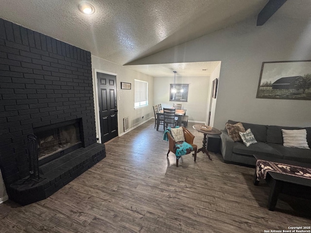 1817 Dusk Dr, Killeen, TX 76543 - living area featuring a textured ceiling, lofted ceiling, dark wood-style flooring, a fireplace, and baseboards