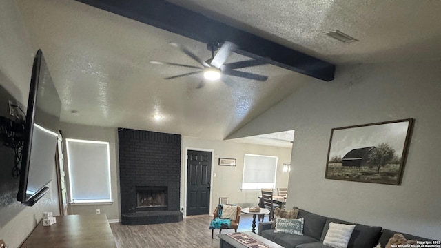 1817 Dusk Dr, Killeen, TX 76543 - living room featuring wood finished floors, a textured ceiling, ceiling fan, and a brick fireplace