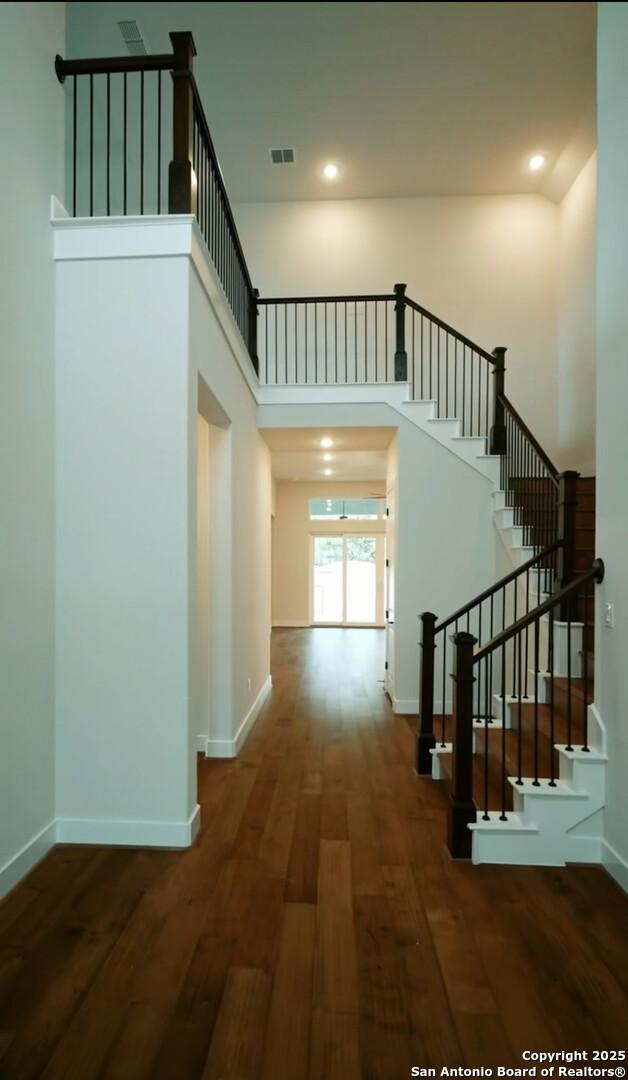 2710 Creekside Vw, San Antonio, TX 78230 - corridor featuring a towering ceiling, wood finished floors, stairway, baseboards, and recessed lighting