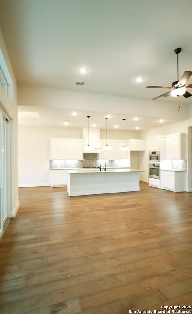 2710 Creekside Vw, San Antonio, TX 78230 - unfurnished living room featuring recessed lighting, ceiling fan, light wood finished floors, baseboards, and a sink