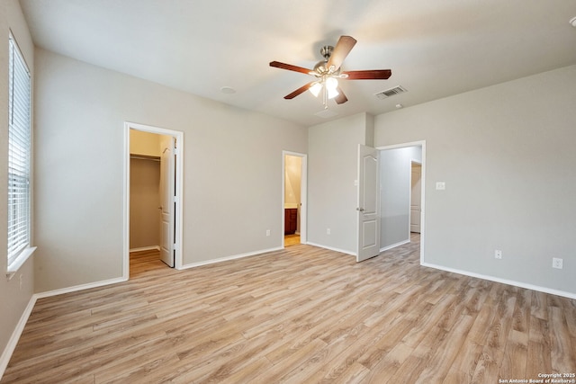 5752 Ping Way, Schertz, TX 78108 - unfurnished bedroom with light wood-style flooring, baseboards, a walk in closet, and a ceiling fan