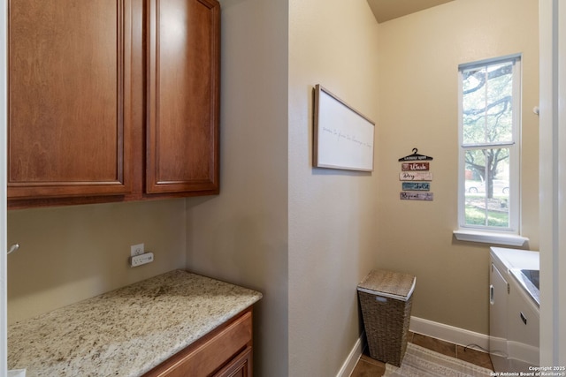 219 Roan Spg, San Antonio, TX 78258 - kitchen featuring brown cabinets, baseboards, and light stone counters