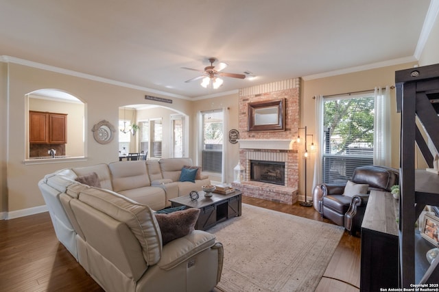 219 Roan Spg, San Antonio, TX 78258 - living room featuring a ceiling fan, arched walkways, wood finished floors, a fireplace, and baseboards